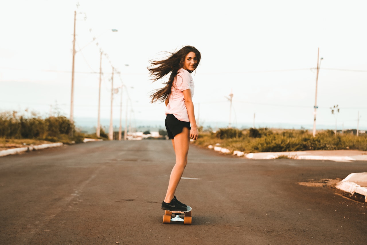 Young woman is riding an electric skateboard
